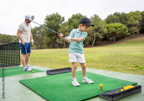 Father with little son playing golf at golf course
