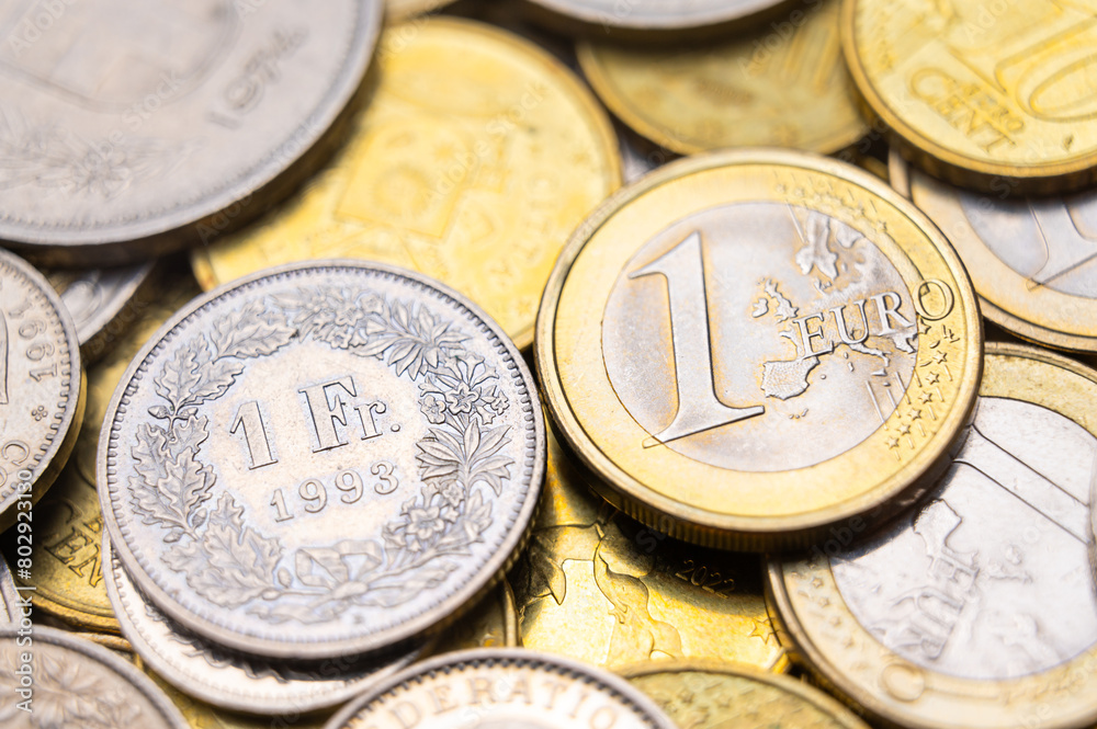 Euro and Swiss Franc coins next to each other, 1 euro and 1 CHF coins Euro and Swiss Franc coins next to each other, 1 euro and 1 CHF coins