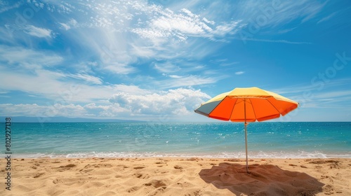 A vibrant beach umbrella provides shade on the sandy shore overlooking the sparkling ocean  with people enjoying the coastal natural landscape under a clear sky AIG50