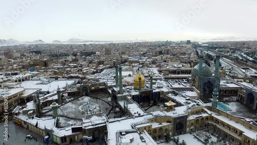 Beautiful snowy day in Qom, Iran. Holy shrine of lady Fatima Masoumeh. Aerial video footage recorded by a drone with high quality rendering in full HD and 4K resolution in nature. photo