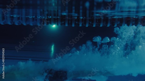 Person diving into a swimming pool POV underwater