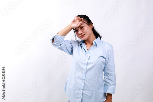 Bothered and tired asian woman, looking complicated, slap forehead, face palm sign and grimacing upset, looking distressed at camera, white background © SetianingDyah