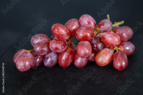 Knackige , frische, rote Weintrauben am Stängel dekoriert. Kernlose Tafeltrauben.
