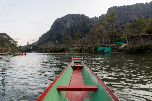 boat going down the river towards mountains in Vang Vieng, the adventure capital of Laos