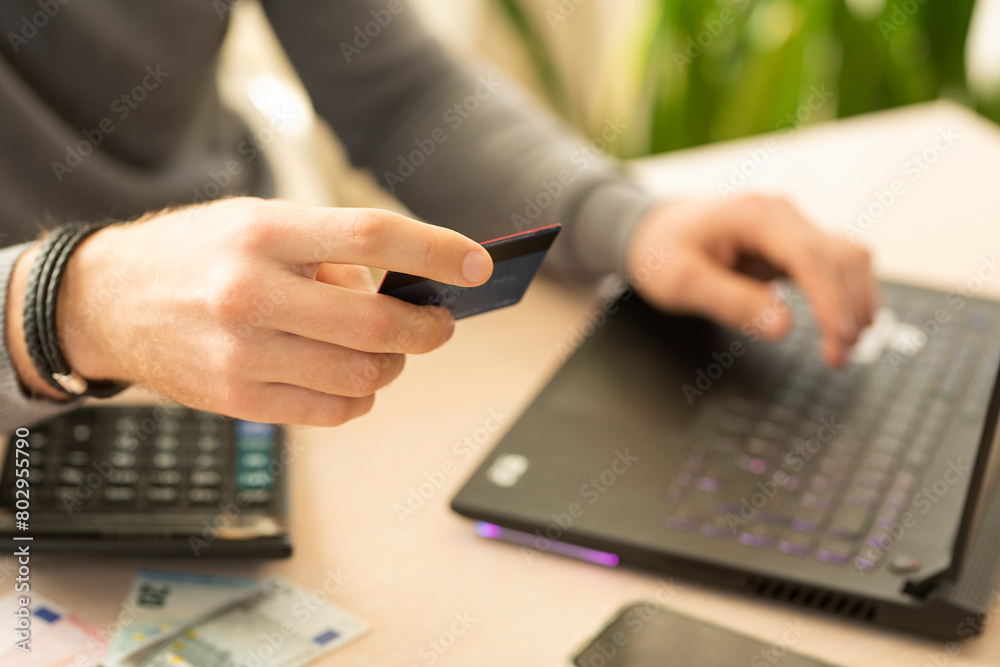 male hands with a bank card in their hands enter data into a laptop. online shopping.banking services
male hands with a bank card in their hands enter data into a laptop. online shopping.banking services