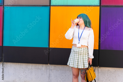Fototapet Nerdy girl with badge drinking a takeaway coffee