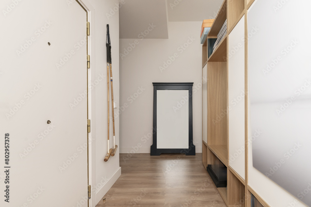 Hallway of a home in the reception area with wooden floors and plain white painted walls Hallway of a home in the reception area with wooden floors and plain white painted walls