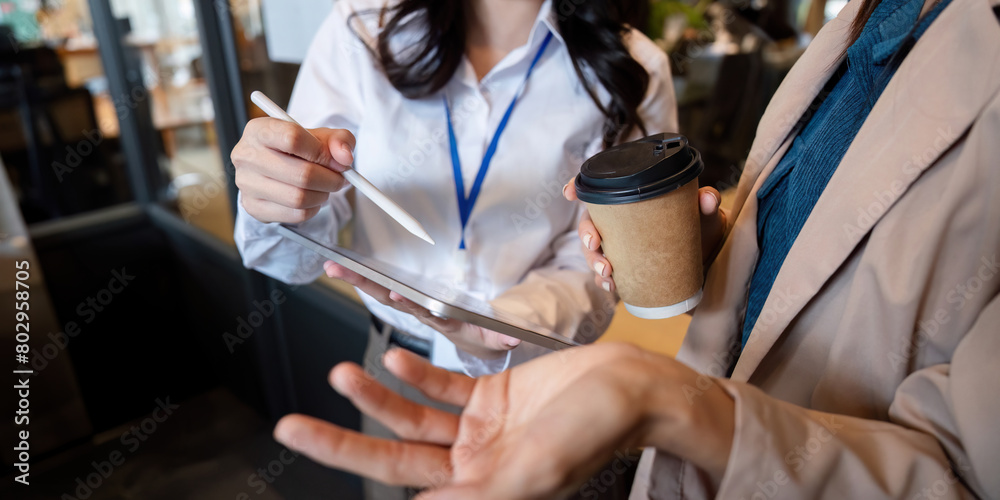 Business team woman working using digital tablet tech discussing financial market data standing at corporate office meeting