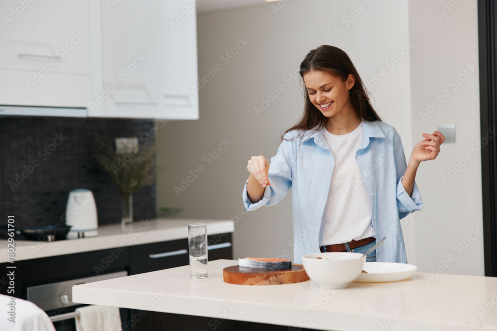Woman in Blue Shirt Enjoying a Bowl of Cereal in Kitchen at Home during Breakfast Time Woman in Blue Shirt Enjoying a Bowl of Cereal in Kitchen at Home during Breakfast Time