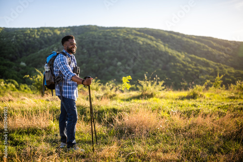 Young man enjoys hiking in nature.