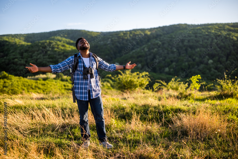 Happy young man hiker with arms raised enjoys in the nature. Happy young man hiker with arms raised enjoys in the nature.
