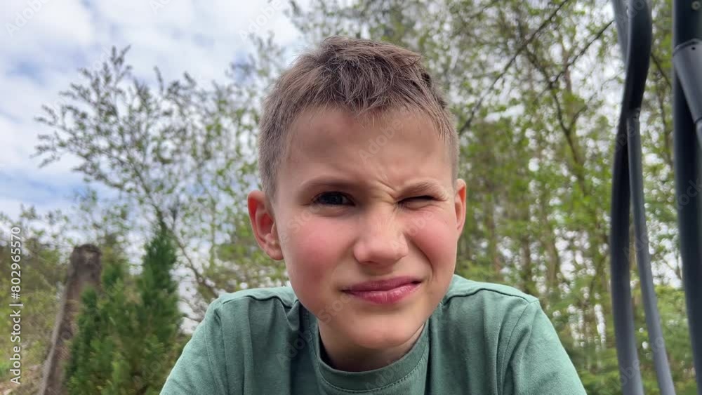 Close-up of the face of a teenager looking at the camera, grinning negatively, looking with contempt and dissatisfaction Close-up of the face of a teenager looking at the camera, grinning negatively, looking with contempt and dissatisfaction