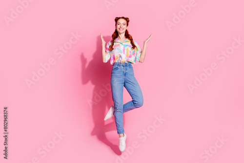 Full size photo of positive cheerful girl dressed colorful blouse jeans pants flying clep her hands isolated on pink color background