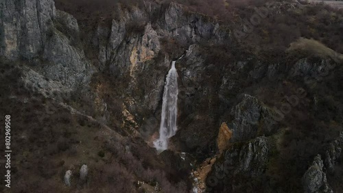Skakavica waterfall. Clear water falling into a dark rocky valley. Drone view of a well-known tourist attraction in Montenegro photo