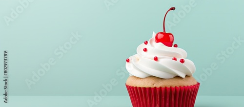 A cupcake adorned with white buttercream decorative icing and a cherry atop it Perfect copy space image