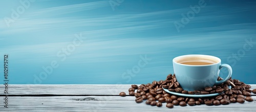 A cup of coffee and roasted brown coffee beans are positioned on blue wooden boards creating a visually appealing copy space image