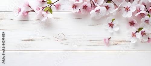 A copy space image with cosmetics and spring flowers placed on a white wooden background