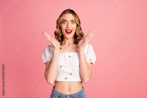 Photo portrait of pretty young girl raise hands shocked wear trendy white outfit hairdo isolated on pink color background