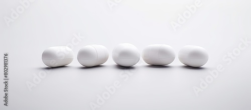 A copy space image showcasing three white pills against a white backdrop