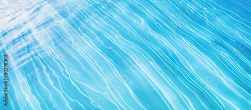 A bright blue swimming pool with a ripple surface is seen from a top view The clear water reflects the sun creating a stunning abstract image that can be used as a texture background or wallpaper The photo