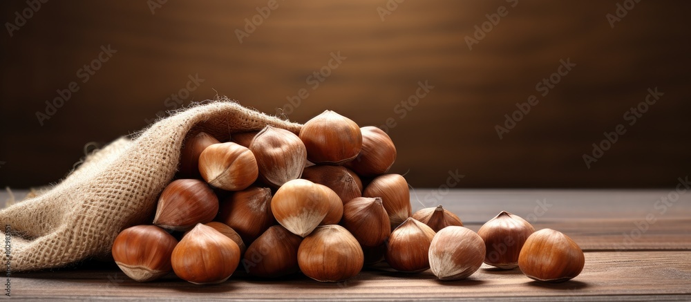 A close up image of hazelnuts contained in a linen bag placed on a wooden table with ample empty space for additional objects or text