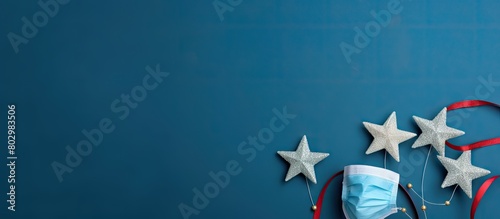 A blue background holds New Year s decorations alongside a medical mask symbolizing the pandemic s impact on Christmas and New Year s celebrations The image offers copy space and showcases a top down photo