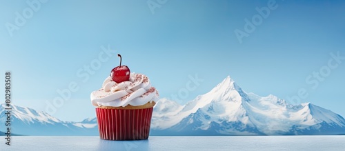 A cupcake with a sign representing the North Pole in the background can be seen in this copy space image photo