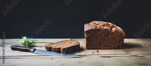 A copy space image of a rustic scene with a slice of brown bread and butter placed on an old knife that rests on a white wooden table photo