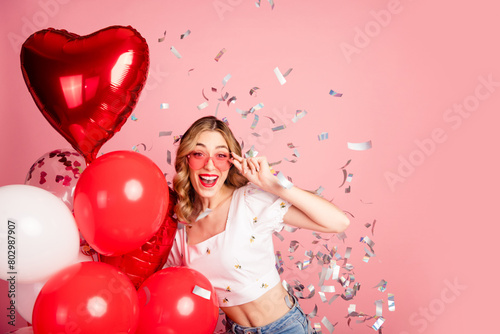 Photo portrait of lovely young woman balloons sunglass confetti dressed stylish white garment hairdo isolated on pink color background