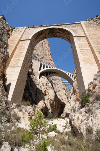 Low angle shot from the bottom of the gorge of the historic Mascarat bridges in Alicante, between the towns of Calpe and Altea, Spain photo