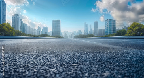 An empty road stretches towards a city skyline in the background, showcasing urban architecture and infrastructure under a clear sky.