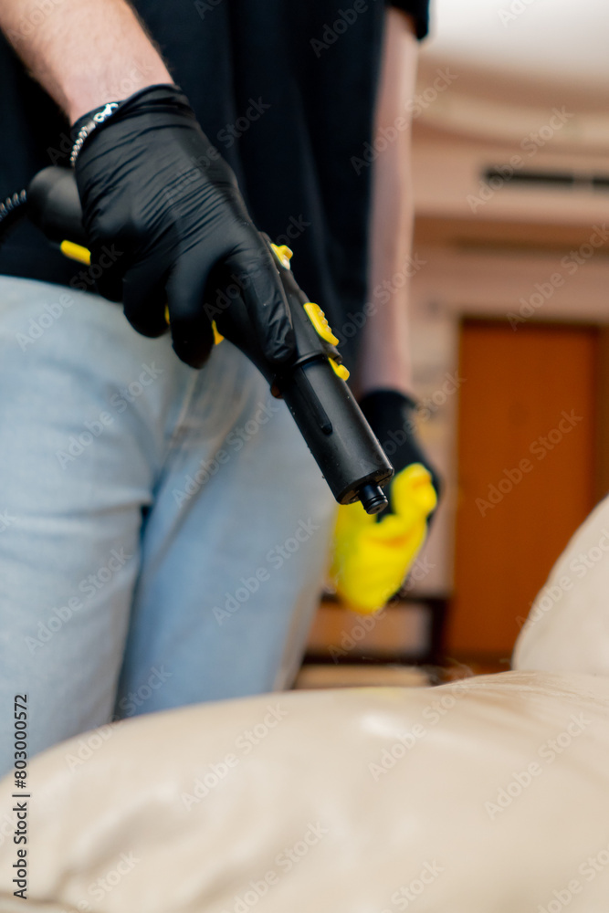 close up professional cleaning of the apartment cleaner steaming the skin on the sofa cleaning furniture