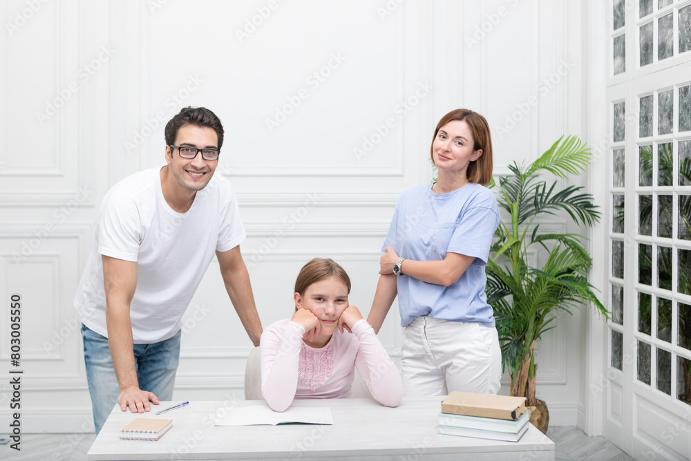Fototapeta premium Portrait of happy family with child daughter studying at home. Home education and parents support concept 