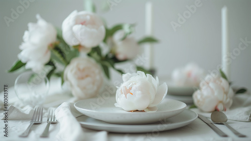 beautifully set table with white tablecloth, adorned with a centerpiece of white peonies, exuding an aura of elegance and tranquility.