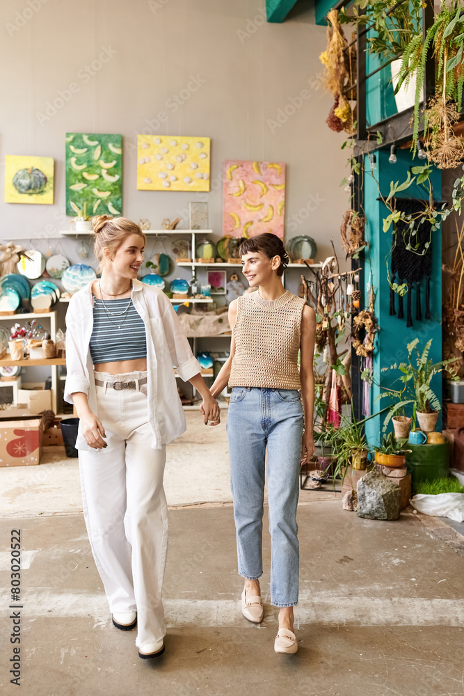 Two women gracefully walk in a room surrounded by lush plants. Two women gracefully walk in a room surrounded by lush plants.
