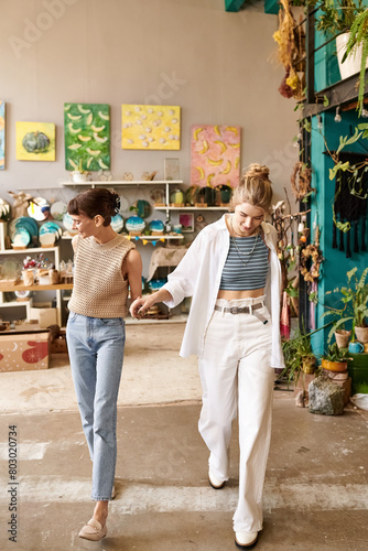 Lesbian couple walk among vibrant art.