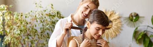 Loving lesbian couple in art studio, one woman brushing partners hair.