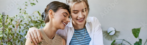 Two arty women, a loving lesbian couple, standing together at an art studio.