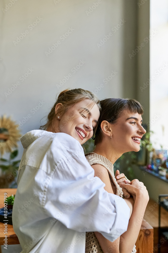 A loving lesbian couple standing together in an art studio. A loving lesbian couple standing together in an art studio.