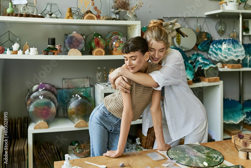 A tender moment shared between two women as they hug in an arty shop. photo