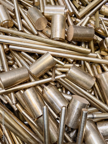 Scrap brass rods and bars in a random heap ready for recycle or re-use