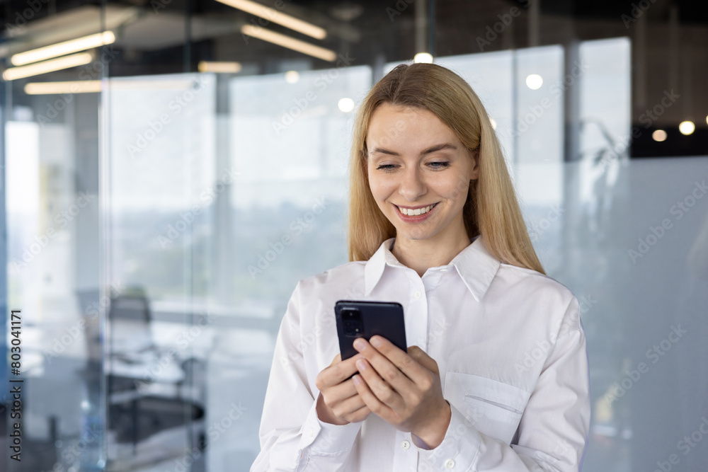 Professional woman using smartphone in modern office
