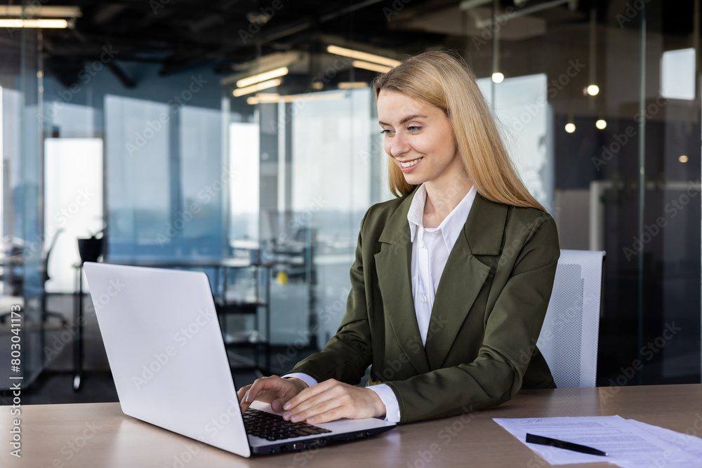 Professional woman working on laptop in modern office