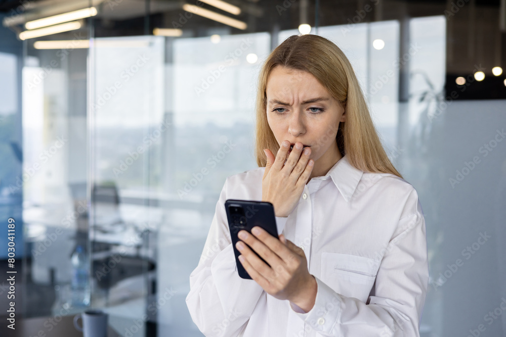 Shocked businesswoman reading a message on her smartphone