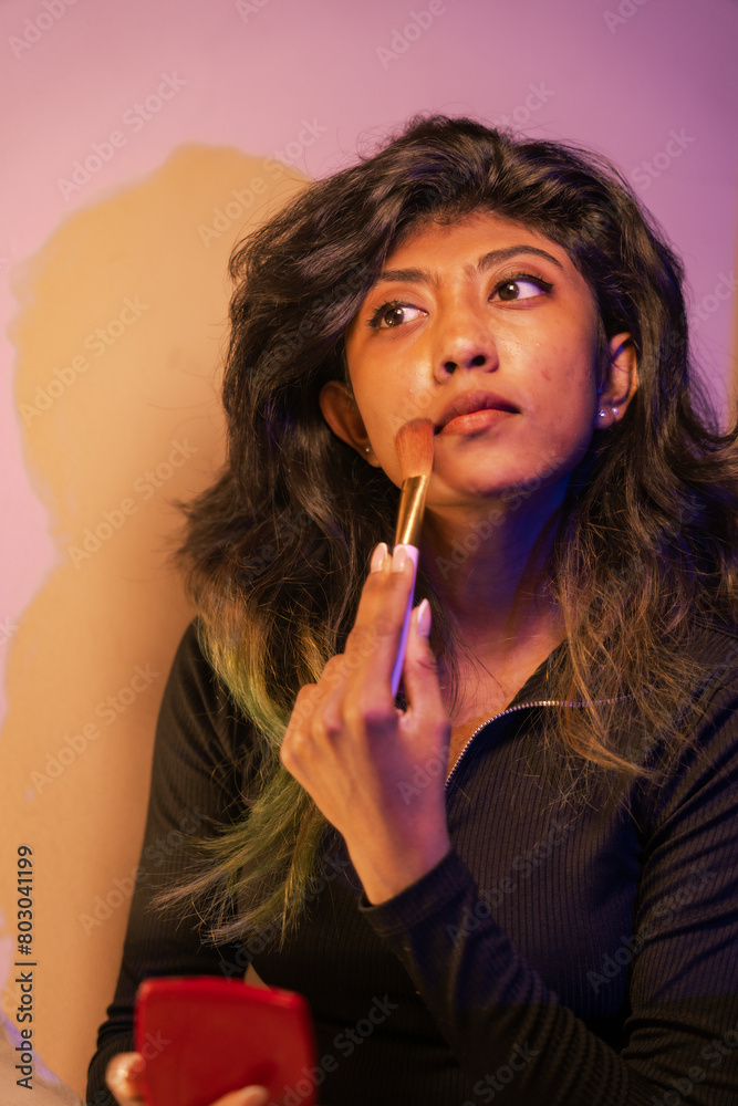 Fototapeta premium A woman is applying makeup with a brush