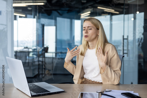 Businesswoman suffering from heat in a modern office
