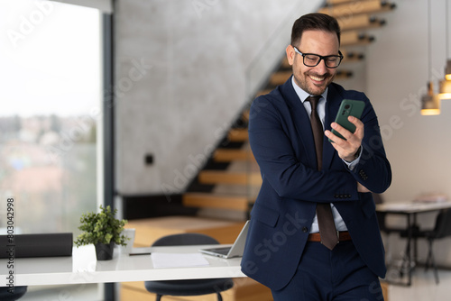 Schilderij op canvas A smiling businessman using smartphone