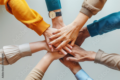 Crop coworkers stacking hands on white background