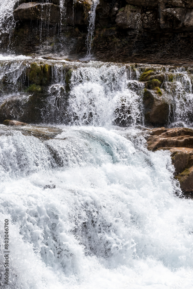 a lively waterfall cascading over rocks, surrounded by moss, embodying the energy and beauty of nature a lively waterfall cascading over rocks, surrounded by moss, embodying the energy and beauty of nature