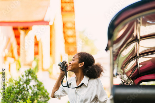 Εκτύπωση καμβά smiling black tourist girl taking photograph outside tuk tuk ride